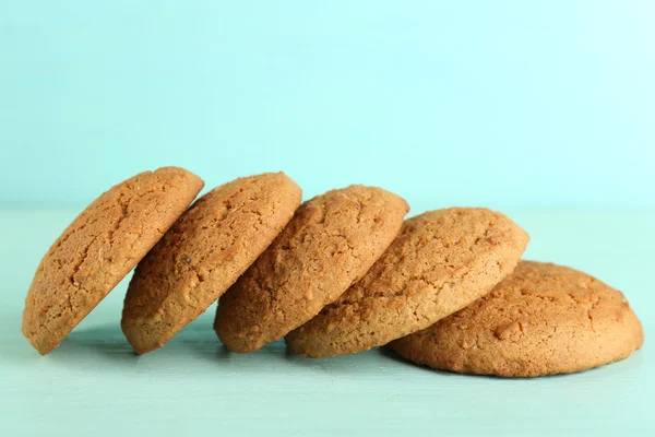 Leckere Plätzchen auf farbigem Holzhintergrund — Stockfoto