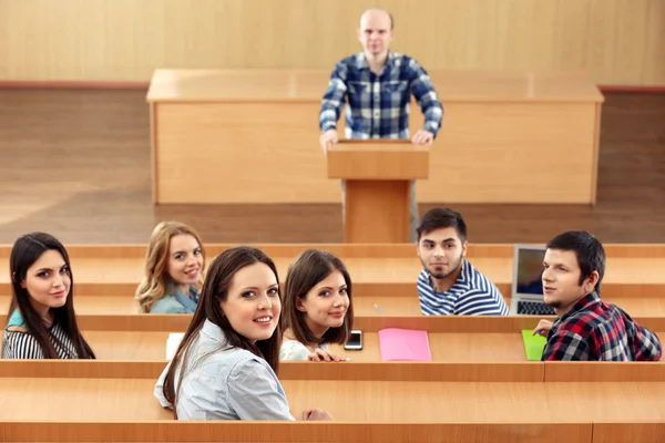 Groupe d'étudiants assis en classe et enseignant à l'écoute — Photo