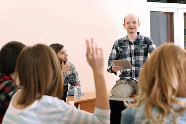 Groupe d'étudiants assis en classe et enseignant à l'écoute — Photo