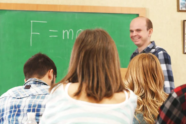 Grupa studentów siedzi w klasie i słuchanie nauczyciela — Zdjęcie stockowe