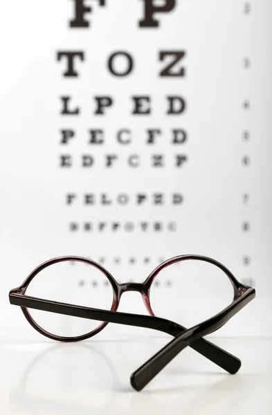 Óculos na tabela dos olhos — Fotografia de Stock