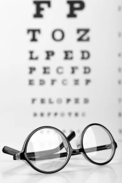 Glasses on eye chart — Stock Photo, Image