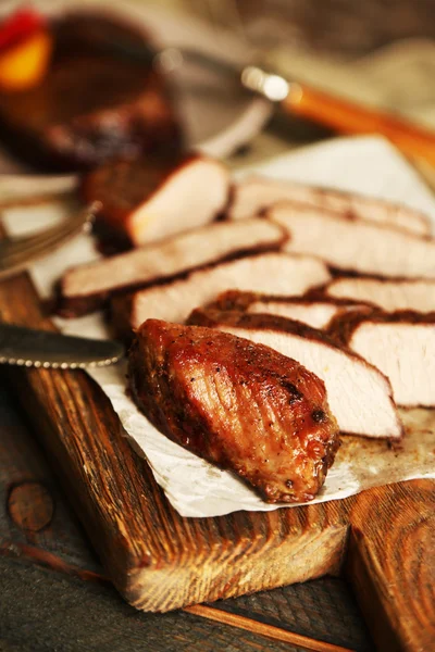 Composizione con carne arrosto a fette su tagliere su fondo di legno — Foto Stock