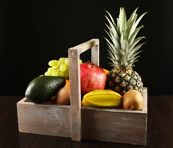 Assortment of fruits in box on dark background — Stock Photo, Image