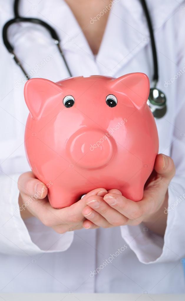Doctor with pink piggy bank