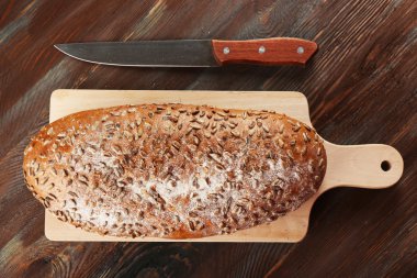 Ahşap arka plan üzerinde kesme tahtası üzerinde taze ekmek