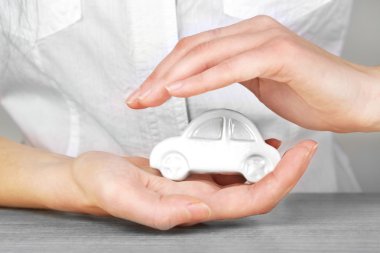 Hands and toy car. Protection of car concept clipart