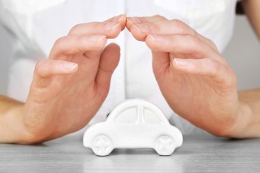 Hands and toy car. Protection of car concept clipart