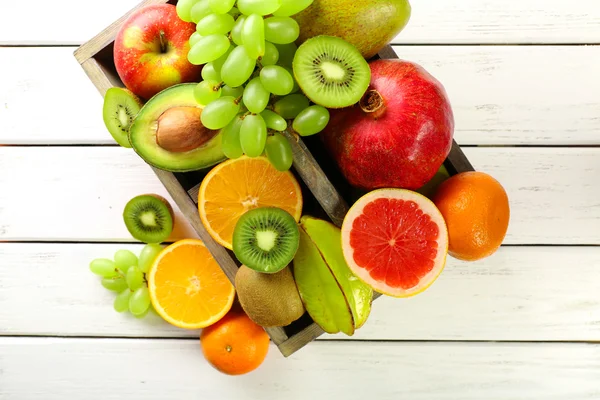 Sortimento de frutas na caixa na mesa de madeira — Fotografia de Stock