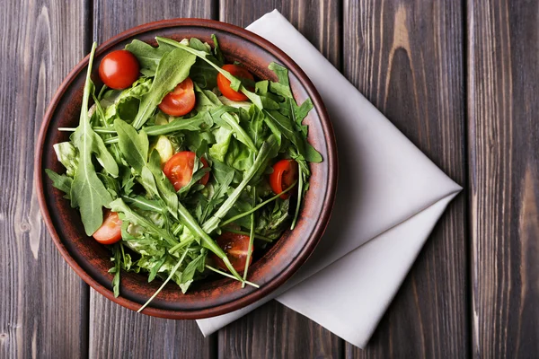 Sallad med ruccola och körsbärstomater på träbord — Stockfoto