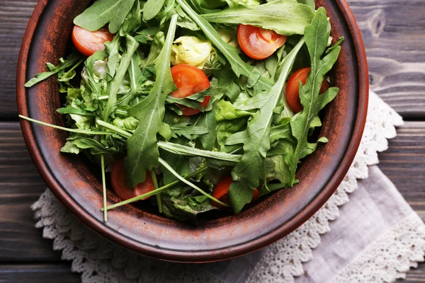 Salad with arugula and cherry tomatoes on wooden table — Stock Photo, Image