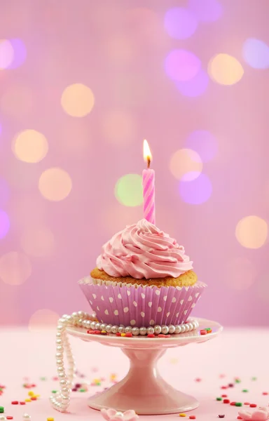 Delicioso cupcake na mesa no fundo brilhante — Fotografia de Stock