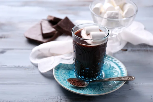 Cioccolata calda con marshmallow in vetro, su sfondo di legno a colori — Foto Stock