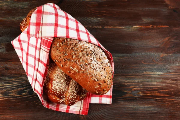 Frische Brote mit Brötchen und Serviette auf Holztisch in Großaufnahme — Stockfoto