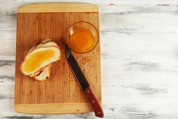 木製のテーブルにまな板の上に蜂蜜とスライスした新鮮なパンをクローズ アップ — ストック写真