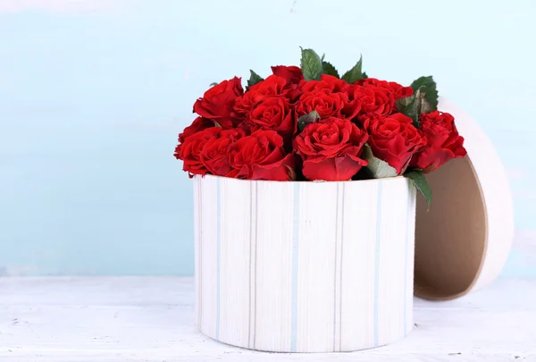 Bouquet of red roses in textile box on wooden background — Stock Photo, Image