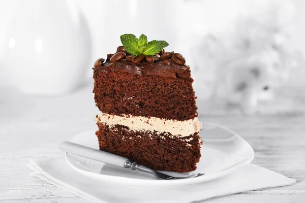 Delicioso bolo de chocolate na mesa no fundo claro — Fotografia de Stock