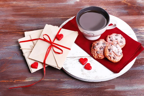 Liefdesbrieven met koffie en koekjes op houten achtergrond — Stockfoto