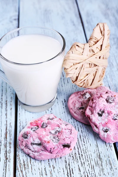Pink cookies and cup with milk on table close-up — Stock Photo, Image