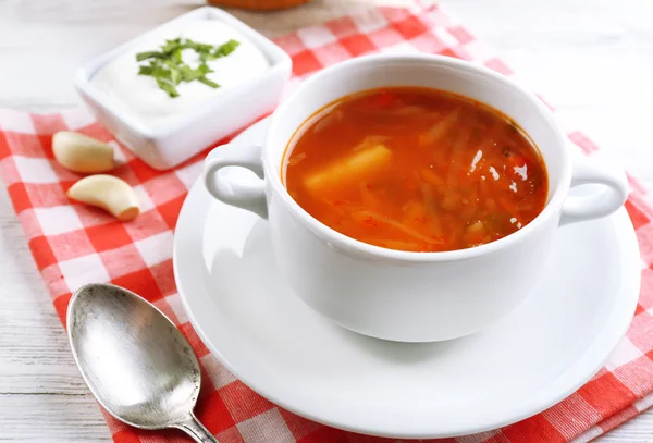 Ukrainian beetroot soup - borscht, on napkin, on wooden background — Stock Photo, Image