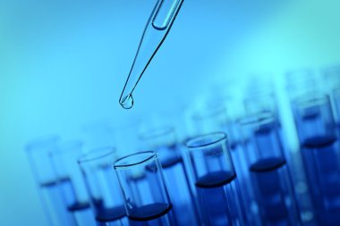 Pipet sıvı test tüpleri mavi arka plan üzerinde bir ekleme