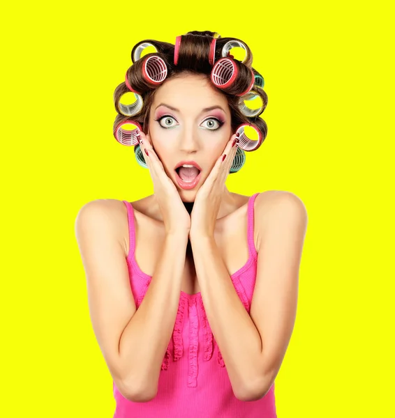 Beautiful girl in hair curlers on yellow background — Stock Photo, Image