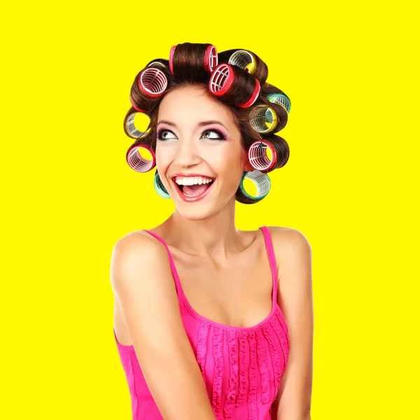 Beautiful girl in hair curlers on yellow background — Stock Photo, Image