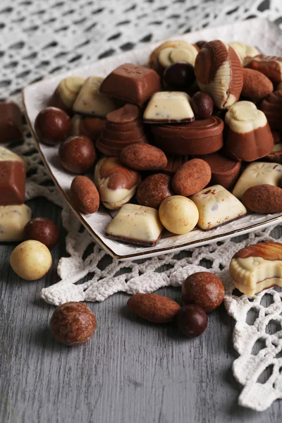 Différents types de chocolats sur plaque sur table en bois — Photo