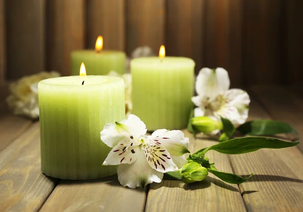 Beautiful candles with flowers on wooden background Royalty Free Stock Photos