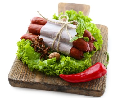 marul salata yaprakları ve baharat üzerine beyaz izole, ahşap kesme tahtası üzerinde ince Sosis füme