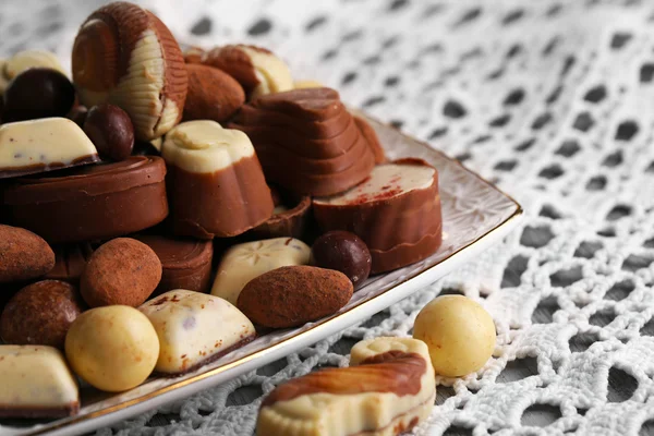 Verschillende soorten chocolade op plaat op houten tafel — Stockfoto
