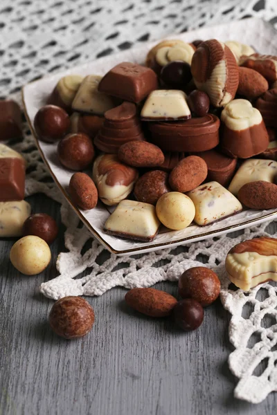 Olika sorters choklad på plattan på träbord — Stockfoto