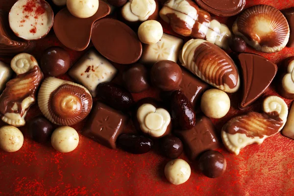 Différents types de chocolats sur fond rouge — Photo