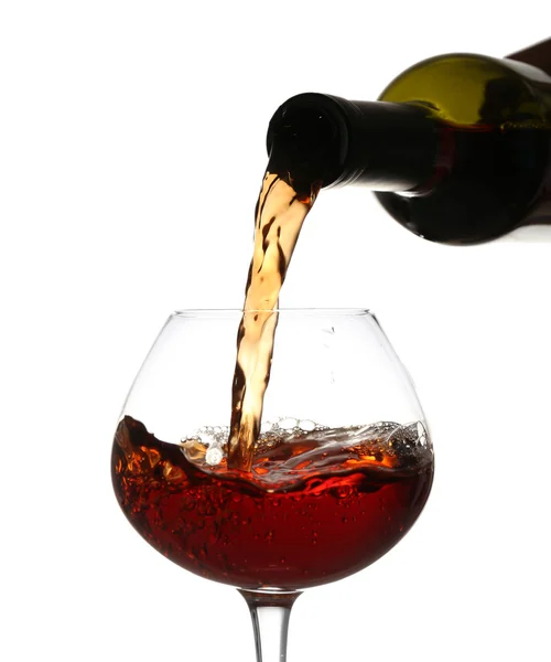 Vinho tinto derramando em copo de vinho, isolado em branco — Fotografia de Stock