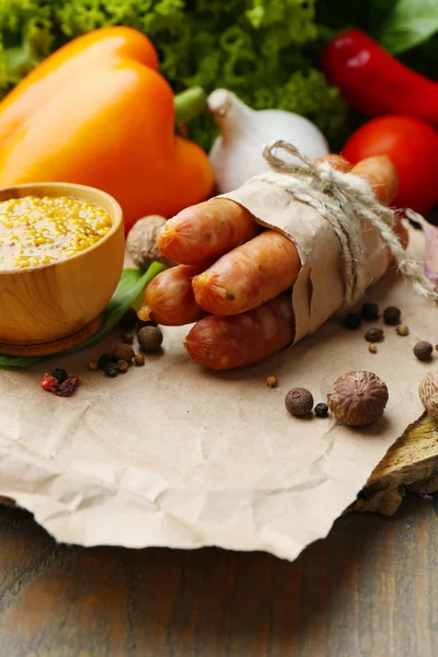 Samenstelling van dunne worst, mosterd in kom en specerijen op houten achtergrond — Stockfoto
