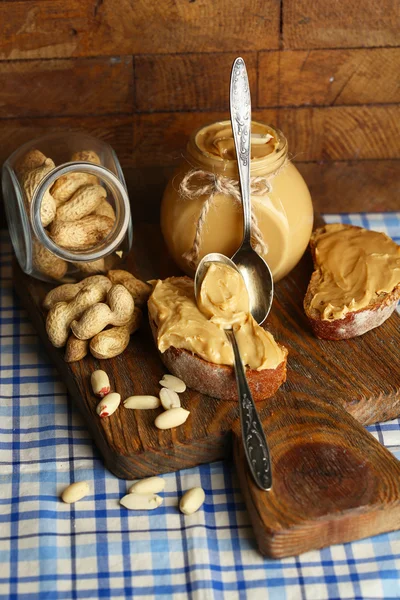 Вкусные сэндвичи со свежим арахисовым маслом на деревянном фоне — стоковое фото