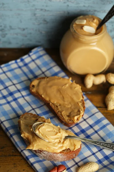 Beautiful still life with fresh peanut butter on wooden background — Stock Photo, Image