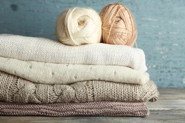 Ahşap arka plan üzerinde iplik ve giysileri örgü