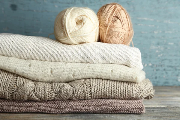 Ahşap arka plan üzerinde iplik ve giysileri örgü