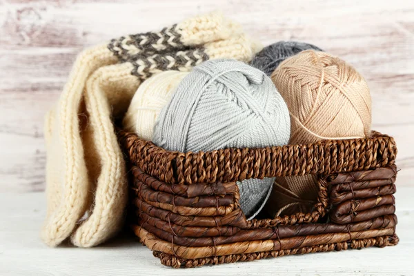针织用纱和袜子在篮子里，木质的背景 — 图库照片