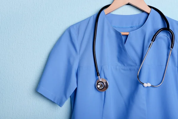 Camisa médica con estetoscopio en percha sobre fondo azul —  Fotos de Stock