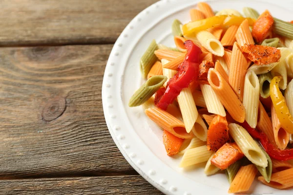 Ensalada de pasta con pimienta, zanahoria y tomates sobre fondo de mesa de madera — Foto de Stock