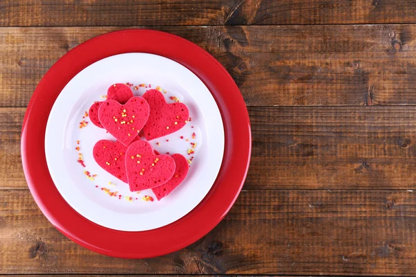 Biscotti in forma di cuore in piatto su tavole di legno rustico sfondo — Foto Stock