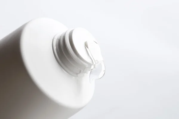 Líquido cosmético que vierte de la botella aislada en blanco — Foto de Stock