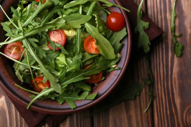 Roka ve ahşap masa üzerinde domates salatası