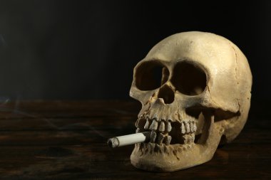 İnsan kürek ile koyu arka plan üzerinde ağzında sigara sigara