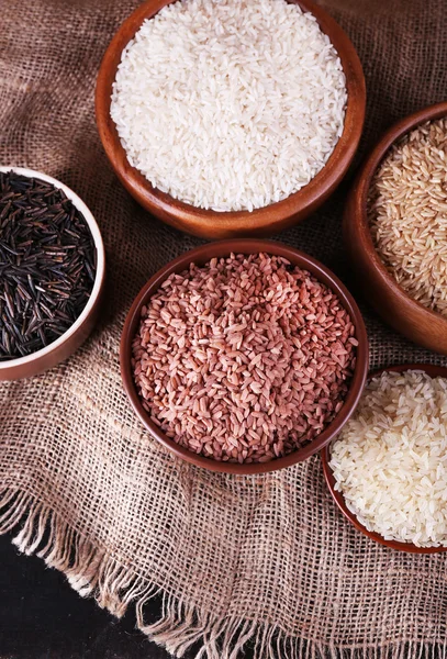 Diferentes tipos de arroz em tigelas no fundo saco — Fotografia de Stock