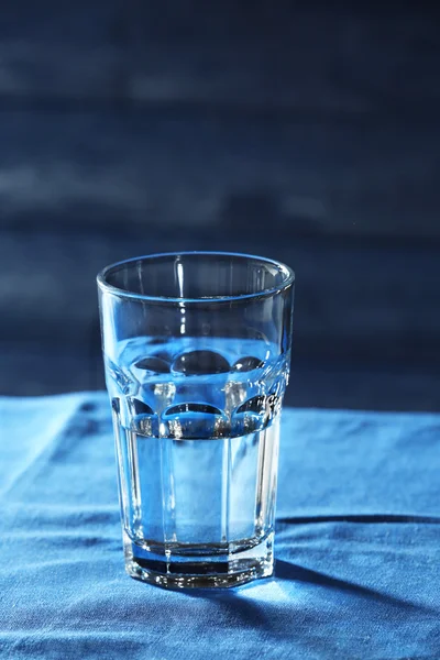 Glass of water on table on wooden background — Stock Photo, Image