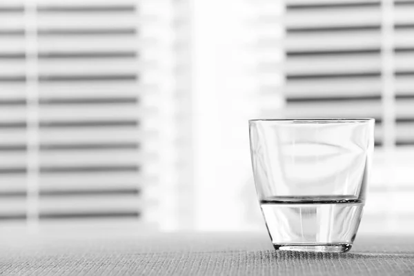 Bicchiere d'acqua sul tavolo su sfondo chiaro — Foto Stock