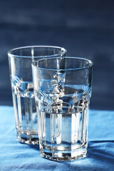 Dos vasos de agua sobre la mesa sobre fondo de madera — Foto de Stock